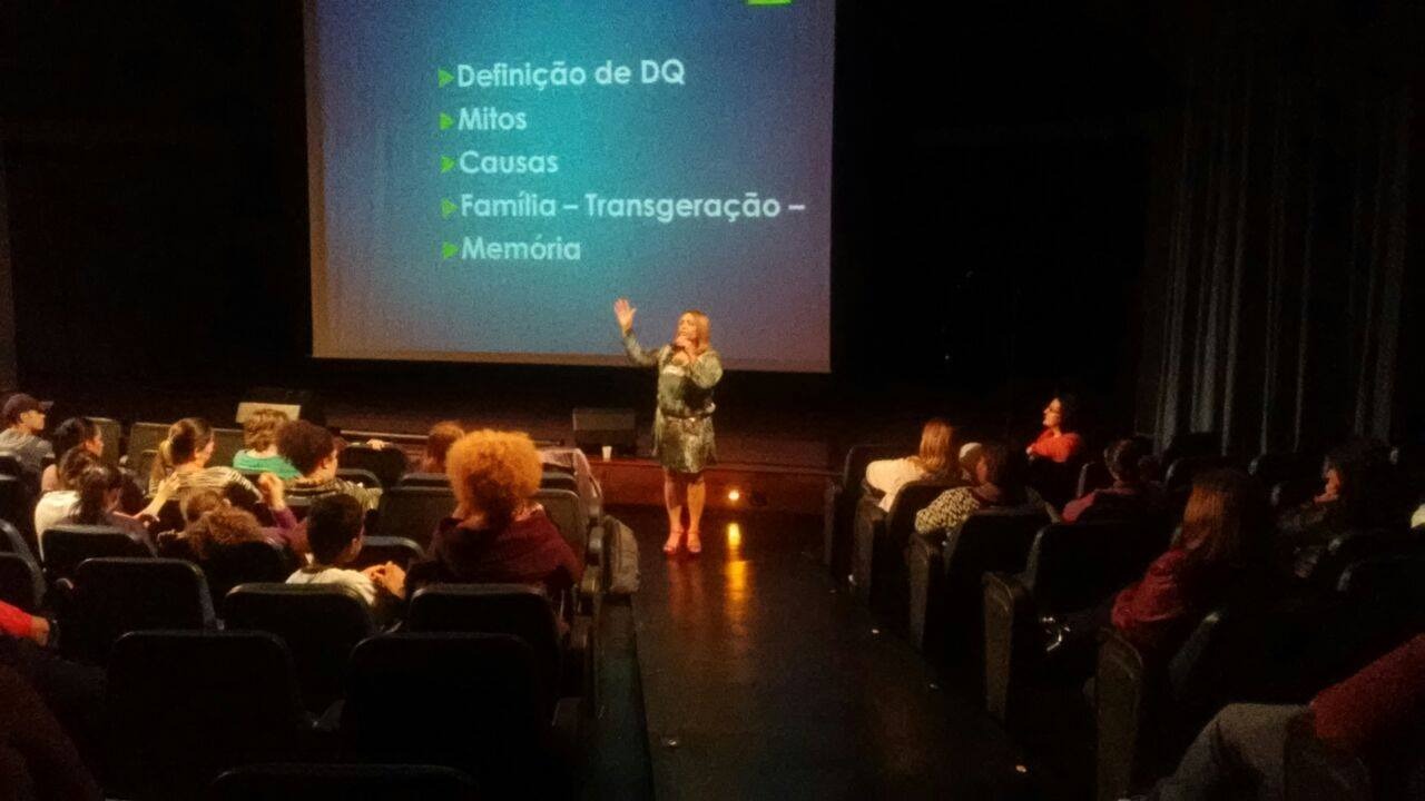 Cilene Nunes em palestra em teatro com plateia atenta